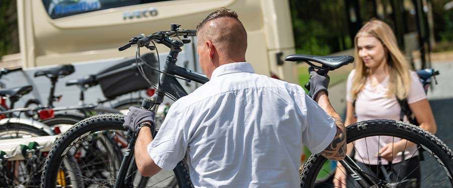 Ein Busfahrer der KomBus stellt ein Fahrrad auf den Anhänger