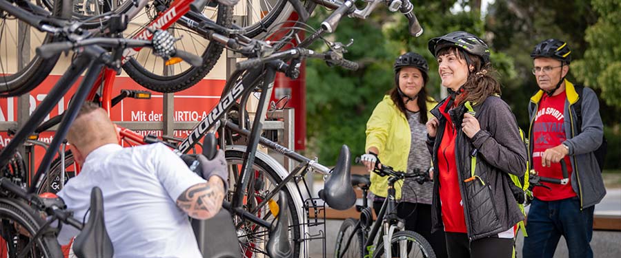 Ein Busfahrer der KomBus hängt ein Fahrrad an den Fahrradträger des Busses